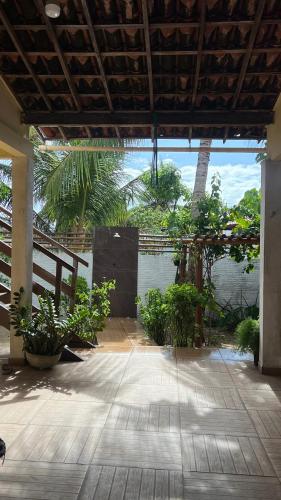 a patio with plants and a view of the ocean at Paraíso Particular- Casa na Praia De Camurupim- Pedra Oca in Nísia Floresta