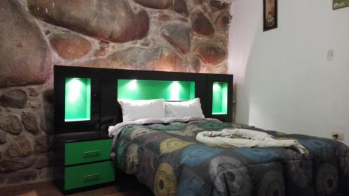 ein Schlafzimmer mit einem Bett und einer Steinmauer in der Unterkunft El Mirador del Inka Hostel in Cusco