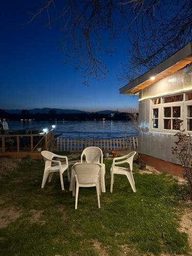 a group of chairs and a table in the grass at The Nigeen Lodge in Srinagar