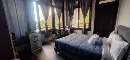 a bedroom with a bed and a large window at HOTEL D&S Ch'umil in Tzununá