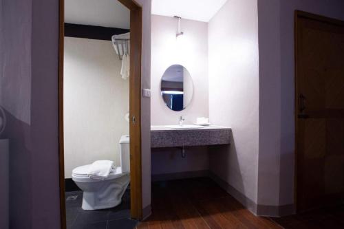 a bathroom with a toilet and a sink with a mirror at Vince Sakon in Sakon Nakhon