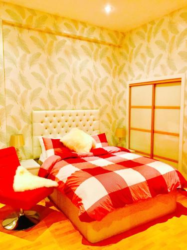 a bedroom with a bed and a red chair at Glasgow City Center Flat with Parking in Glasgow