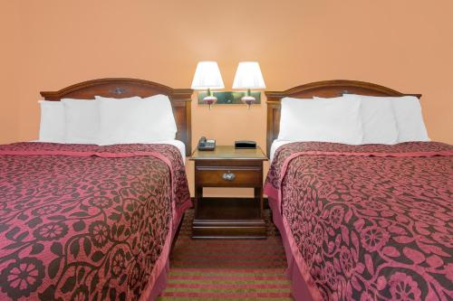 two beds sitting next to each other in a hotel room at America Best Value Inn Kosciusko in Kosciusko