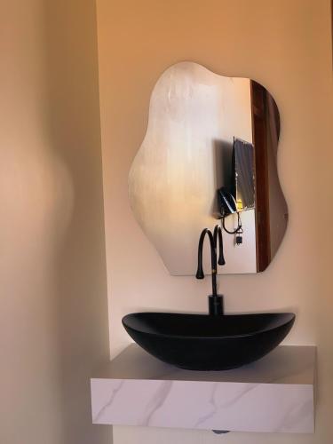 a bathroom with a black sink and a mirror at Black Win Hotel Phu Yen in Mỹ Hòa (1)