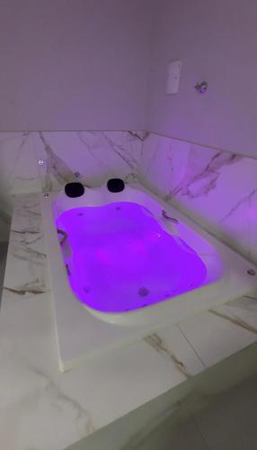 a purple room with a tub in a ceiling at Alphaville Hotel in Barra do Bugres