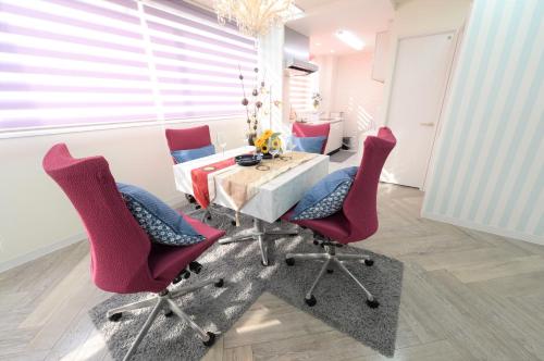 a dining room with red chairs and a table at Sweet House Umeda Minami in Osaka