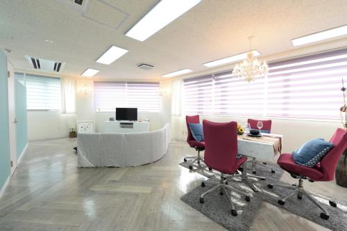 an office with red chairs and a desk and a tv at Sweet House Umeda Minami in Osaka