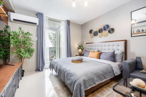 a bedroom with a bed and a couch at Airport Haven Condotel - near Mactan-Cebu Airport 13 mins ride, Self Check-In, Wifi, Netflix, pool and Balcony view in Lapu Lapu City