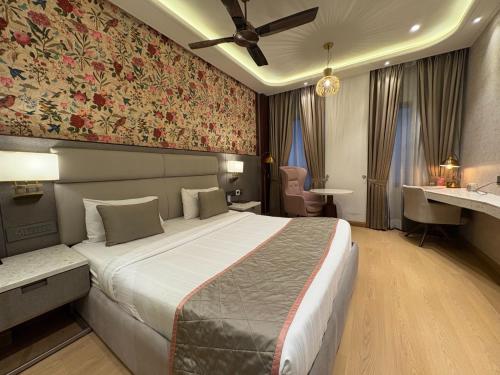 a bedroom with a large bed with a floral wall at Hotel Rajshree & Spa in Chandīgarh