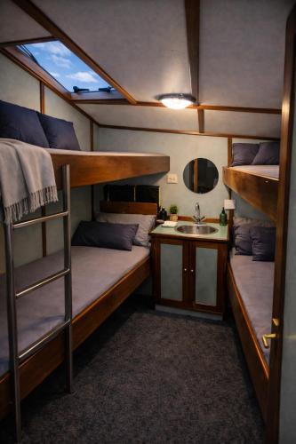 a small room with two bunk beds and a sink at Zeilschip de Alliantie Kampen in Kampen