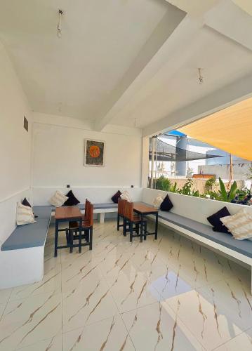 a living room with two tables and chairs at NeNa Eat & Sleep Kuta in Kuta Lombok