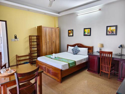 a bedroom with a bed and a desk and a table at Sunny C Hotel in Hue
