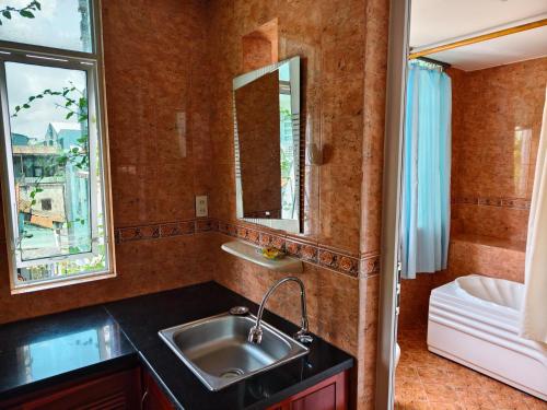 a bathroom with a sink and a mirror at Sunny C Hotel in Hue