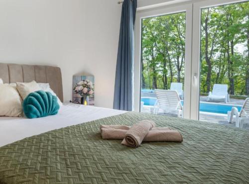 a pair of towels on a bed in a bedroom at Villa Peace Oasis in Lovreć