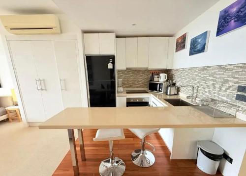 a kitchen with a table and a black refrigerator at Sea-view apartment in Azur in Ban Tai