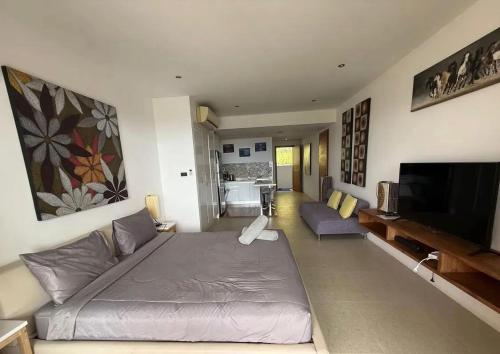 a living room with a bed and a flat screen tv at Sea-view apartment in Azur in Ban Tai