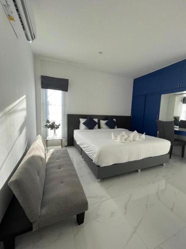 a bedroom with a large bed and a couch at A Day Hotel in Roi Et
