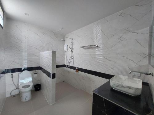 a bathroom with a toilet and a sink at A Day Hotel in Roi Et