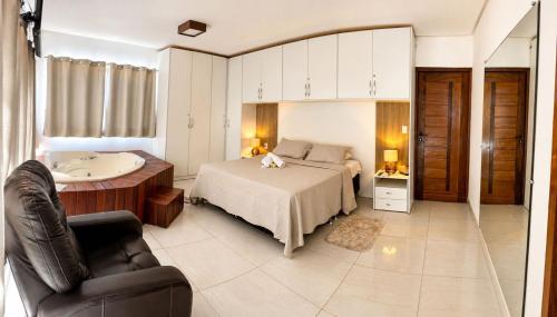 a bedroom with a bed and a tub and a sink at Hotel Fazenda Haras Paraíso do Atlântico in Irecê