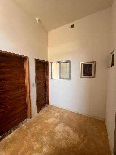 an empty room with a door and a window at Casa Nisadó in San Agustinillo