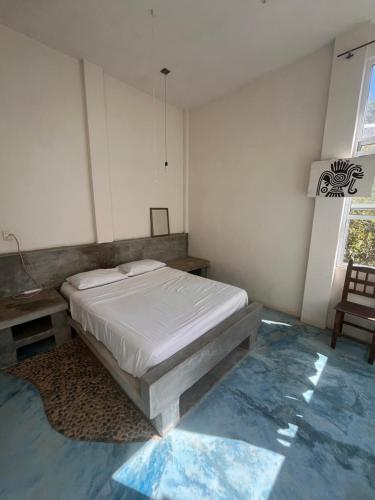 a bedroom with a bed and a table and a chair at Casa Nisadó in San Agustinillo