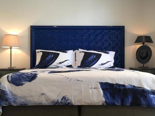 a bedroom with a large bed with a blue headboard at Silverwood House in Woodend