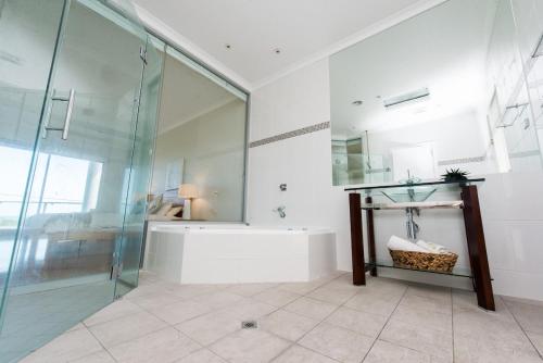 a bathroom with a glass shower and a tub at The Edge in Robe
