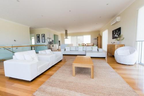 a living room with white couches and a coffee table at The Edge in Robe