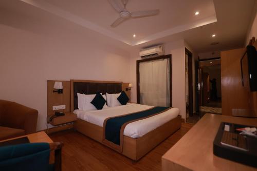 a bedroom with a bed and a living room at Hotel Kohinoor Palace, Ludhiana in Ludhiana