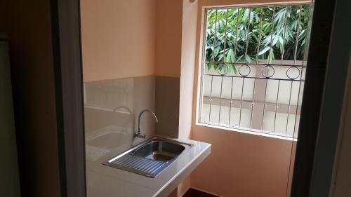 a bathroom with a sink and a window at Jirasin Hotel & Apartment in Ranong