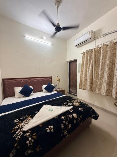 a bedroom with a bed and a ceiling fan at Devansh Palace Near Ram Mandir in Ayodhya