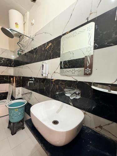 a bathroom with a sink and a mirror at Devansh Palace Near Ram Mandir in Ayodhya