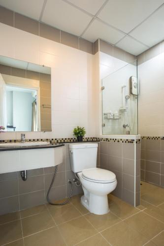 a bathroom with a toilet and a sink and a mirror at Central Place Serviced Apartment in Chon Buri