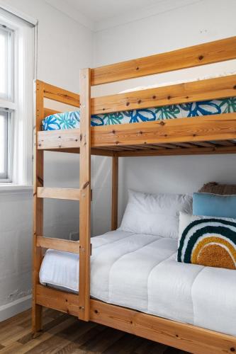 a bedroom with two bunk beds with white sheets at No 5 Red Right on the beach! in Robe