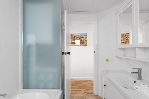 a white bathroom with a sink and a shower at No 5 Red Right on the beach! in Robe
