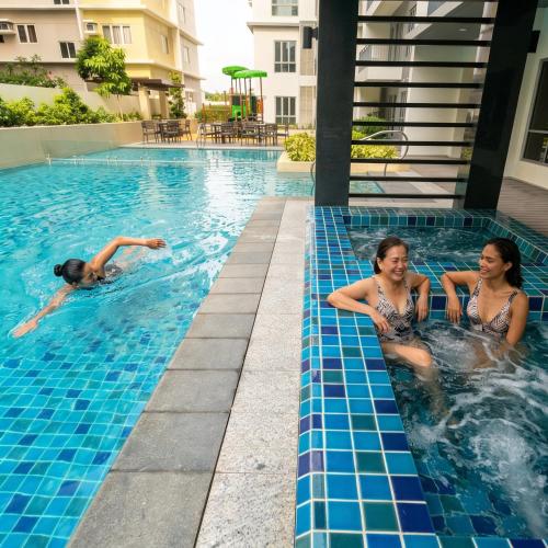 two women in a swimming pool at a hotel at 27th Palace at One Manhattan in Bacolod