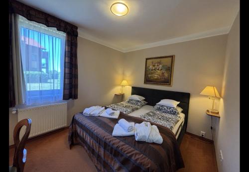 a hotel room with two beds and a window at Apartman Golf Lux in Bük