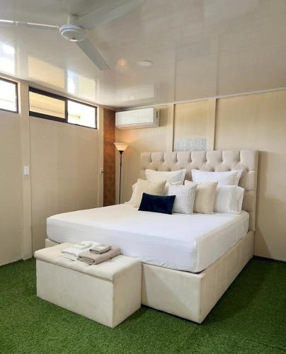 a bedroom with a large white bed with two ottomans at Agujas hostel in Puerto Jiménez