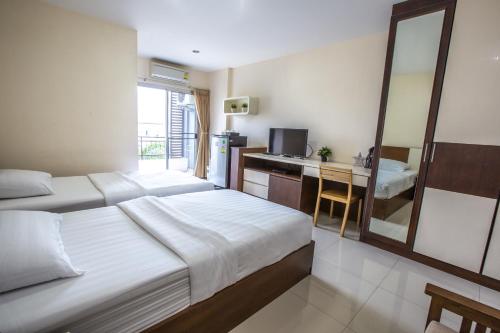 a hotel room with two beds and a desk at Central Place Serviced Apartment in Chon Buri