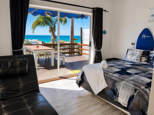 a bedroom with a bed and a view of the ocean at The Deck in Jeffreys Bay