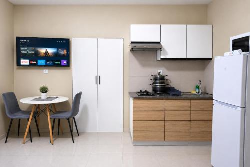 a kitchen with a table and a white refrigerator at Milestone Terrace - Premium Apartment near Airport & Super U in Antananarivo