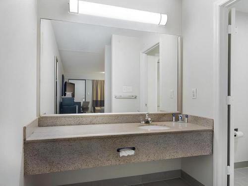 a bathroom with a sink and a large mirror at Rodeway Inn Lumberton Central in Lumberton