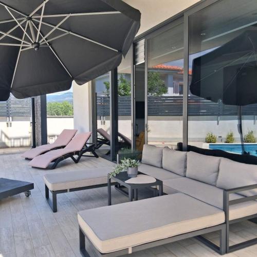 a living room with a couch and tables and umbrellas at Villa Martina Bellevue in Šmrika