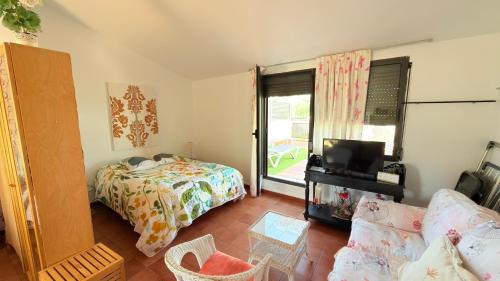 a bedroom with a bed and a tv and a couch at Loft El Carmen in Teruel