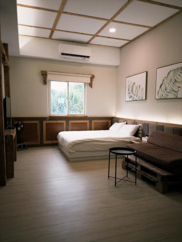 a bedroom with a bed and a couch and a window at 耶舍 yes sir 潛水旅宿1館2館 in Green Island