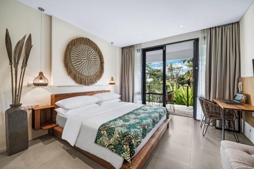 a bedroom with a bed and a desk and a balcony at Ayurvedagram Bali - Wellness & Retreat Resort in Ubud