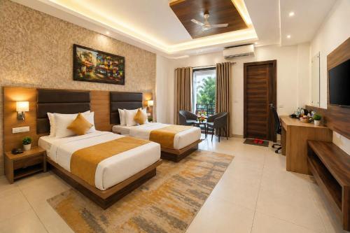 a hotel room with two beds and a television at Hotel Grand Regency by JMD Group Near Delhi IGI Airport in New Delhi