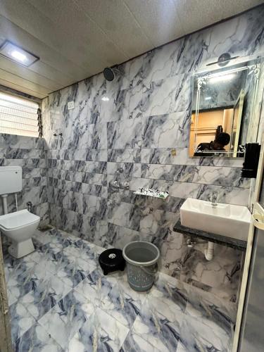 a bathroom with a sink and a toilet at Serenity House in Matheran