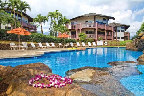 a pool at a resort with chairs and umbrellas at Ka Eo Kai Resort Studio Suite in Princeville