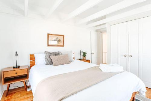 a white bedroom with a large bed and a wooden floor at Green on New in Staunton